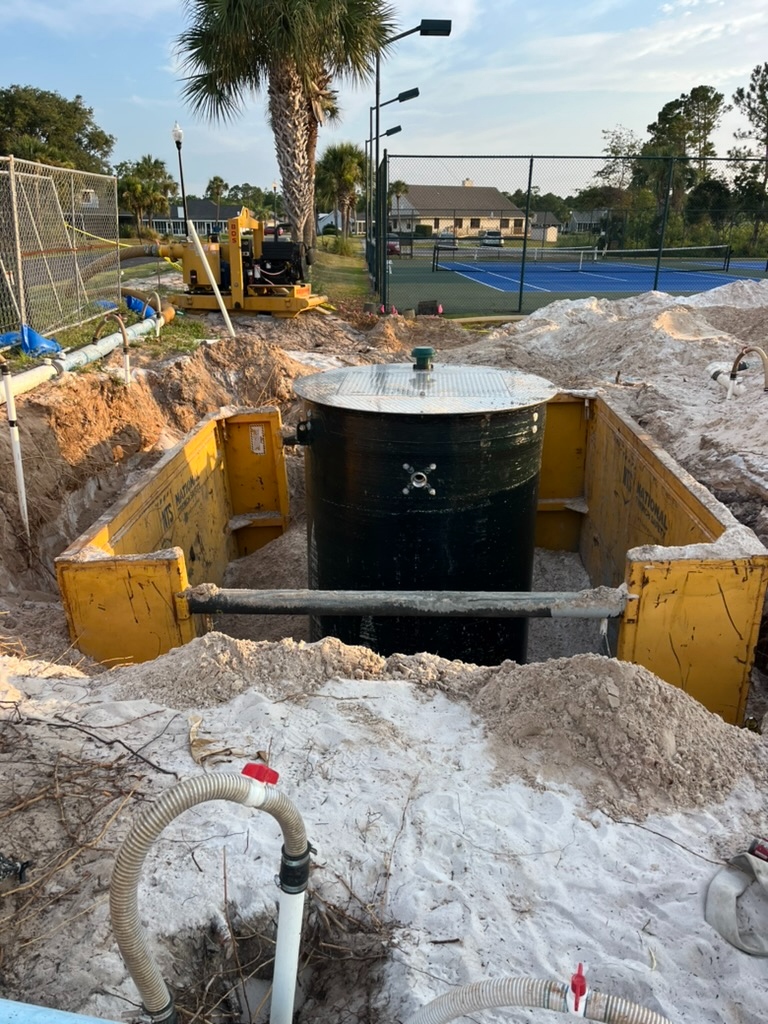 Crew installing a sanitary wet well in a shored excavation