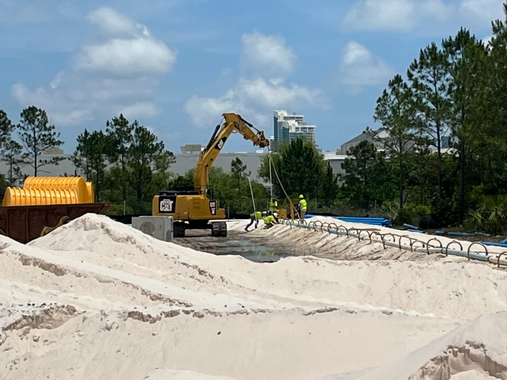 Excavator working a site near a high-rise on the Baldwin County coast